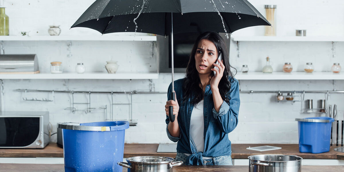 upset woman standing under umbrella in kitchen and 2023 11 27 05 36 47 utc copy